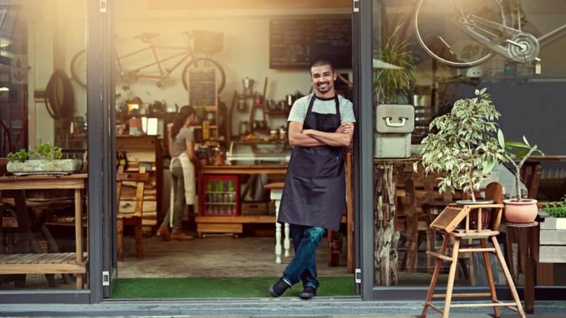 Small business owner standing in the doorway of their shop